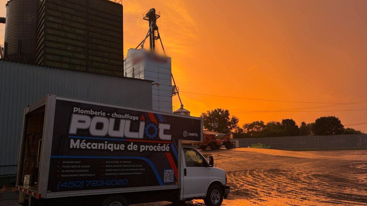Camion cube de Pouliot Plomberie Mécanique devant les silos d’une meunerie au coucher du soleil
